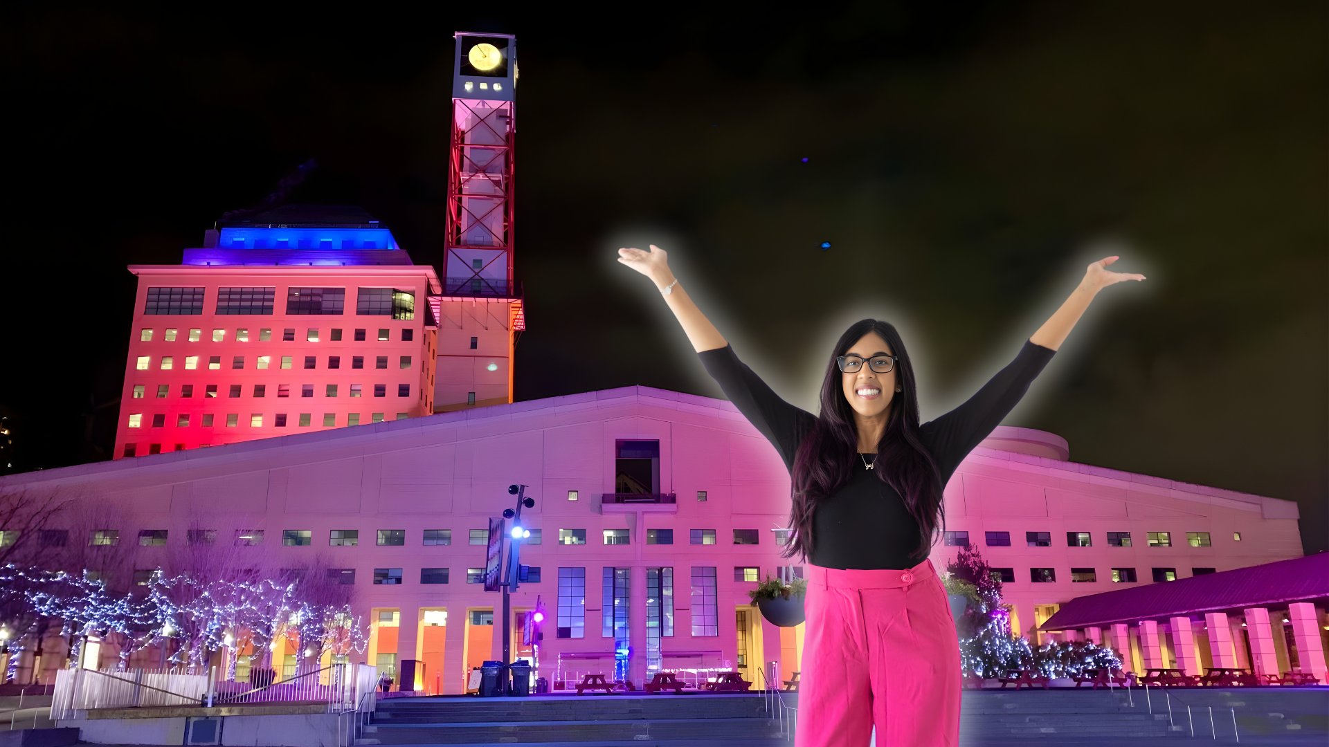 Lauren Pires celebrating in front of the illuminated Mississauga Civic Centre for Rare Disease Day
